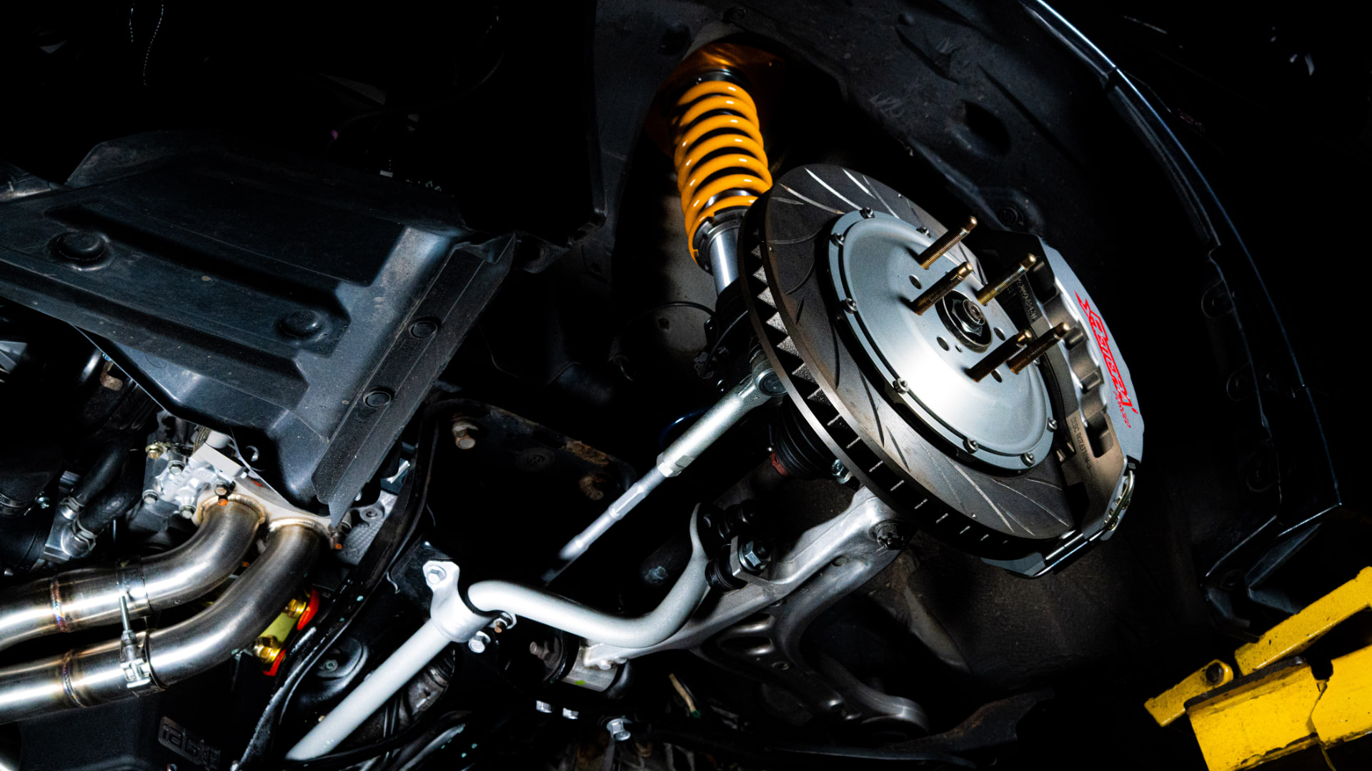 Close-up performance brake and suspension assembly on a modified Subaru
